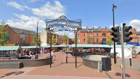 The sign for Bulwell Market, with stalls in the background