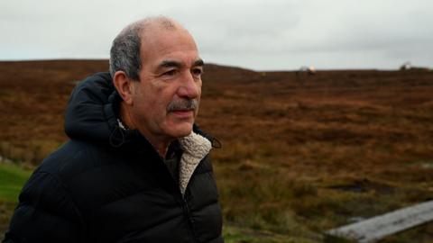 Coinneach Macillinnein, Cathraiche Urras Oighreachd Chàrlabhaigh agus e na sheasachd air a' mhòinteach.