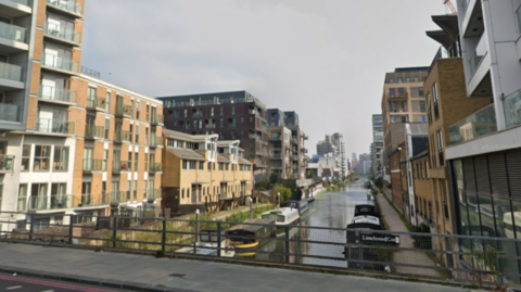 Street view of Limehouse cut showing bridge over canal with boats