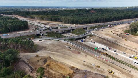 An aerial view of the M25/A3 junction, showing roadworks being carried out and traffic being diverted off the carriageways.