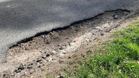 A large pothole on a tarmac road