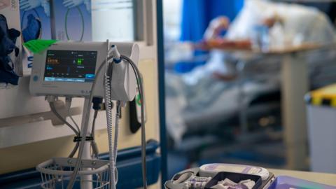 A general view of medical equipment on a NHS hospital ward. A patient in a bed can be seen in the background