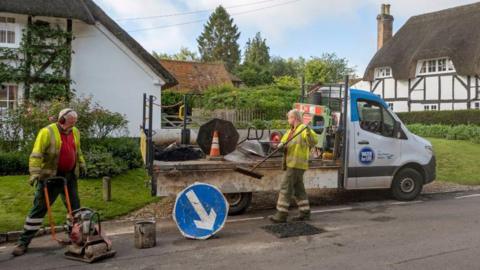 Southern Water employees repairing the road surface after filling a hole in the tarmac.