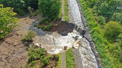 The breach near Polmont resulted in major flooding that's closed the main railway line between Edinburgh and Glasgow.