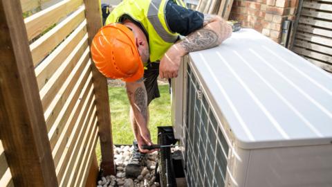 Tradesman installing a heat pump