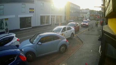 CCTV snapshot of cars along a road.
