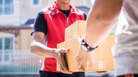 A delivery man hands over parcels
