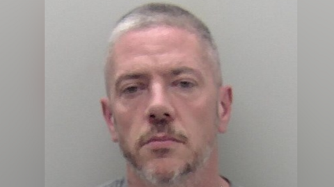 A man with short grey hair and beard.