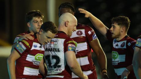 Wigan players congratulate Liam Farrell for his decisive try