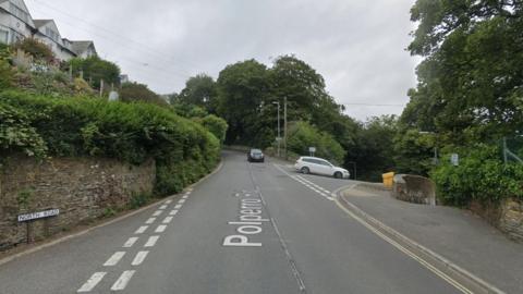 Google Street View image of Polperro Road in West Looe at its junction with North Road on the left as two cars drive down the road.