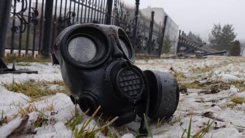 Gas mask near fence of an administrative building in Almaty, 7 January 2022