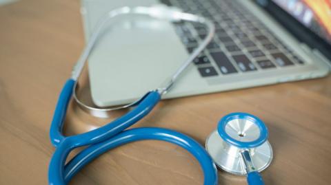 Doctor's desk with laptop and stethoscope