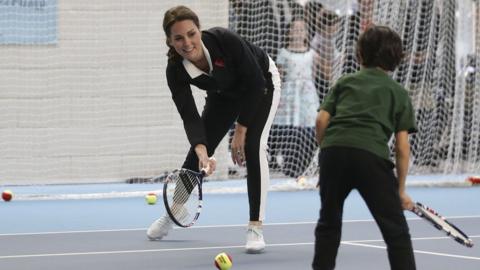 The Duchess of Cambridge playing tennis with a boy