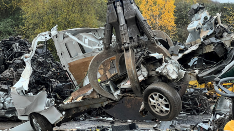 A van being crushed at a recycling plant