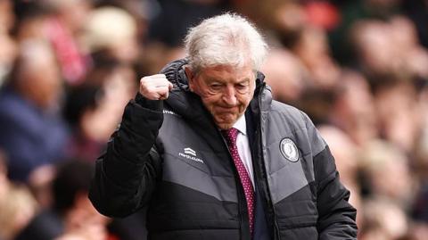 Bristol City manager Roy Hodgson with discreet right-arm fist pump, wearing warm club jaocket with zip half-down showing wine red tie 