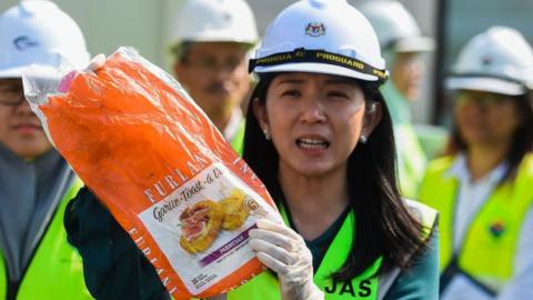 Malaysia's Environment Minister Yeo Bee Yin shows a sample of plastic waste shipment before sending back to the country of origin in Port Klang, west of Kuala Lumpur on May 28, 2019.