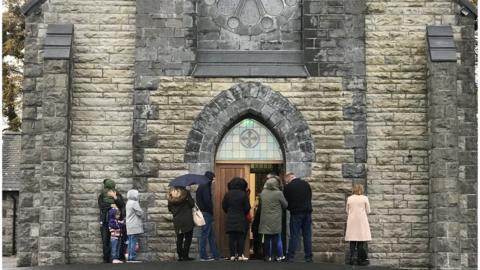 Parishioners standing outside Mass at Immaculate Conception Church in Monea