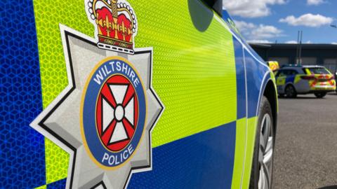 A generic close-up shot of the side of Wiltshire Police car showing the logo