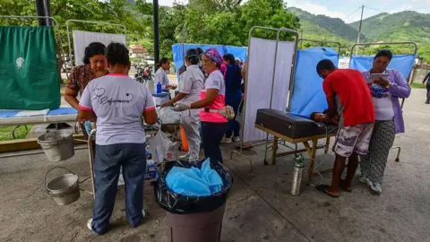 Rescue workers and paramedics set up a makeshift care centre in Moron, Carabobo State