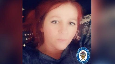 A selfie of woman with red hair and blue eyes wearing a navy top