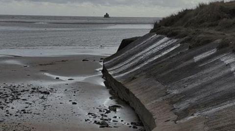 The Humberston Fitties coastal embankment with a beach area in the foreground and the sea in the background.