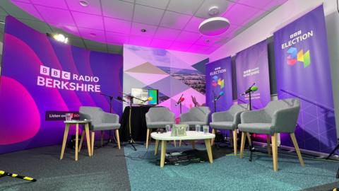 Empty chairs in front of purple signs for the BBC Radio Berkshire election debate