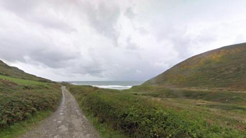 Welcombe Mouth, north Devon. Sea in the distance and grassy slopes either side of a road