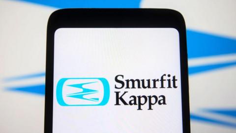 A phone displaying the Smurfit Kappa logo