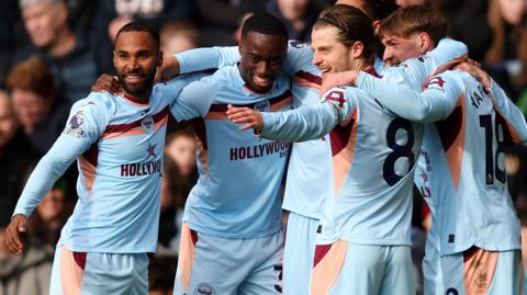 Mikkel Damsgaard of Brentford (obscured) celebrates scoring his team's first goal with his team during the Premier League match between Burnley and Brentford at Turf Moor