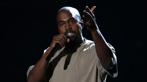Kanye West on stage holding microphone 