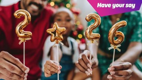 Family holding golden balloons with the numbers 2026.