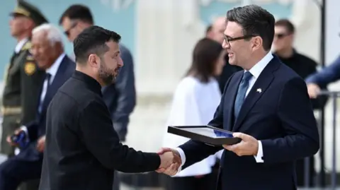 Zelensky shakes hands with Andy Burnham