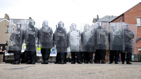 Riot police form a line on the Lower Ormeau road after people taking part in an anti-Islamic protest make their way through the area following a protest outside Belfast City Hall.