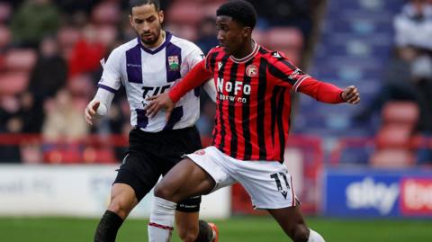 Aaron Loupalo-Bi shields the ball from Barnet's Joe Kizzi while on loan at Walsall last season.