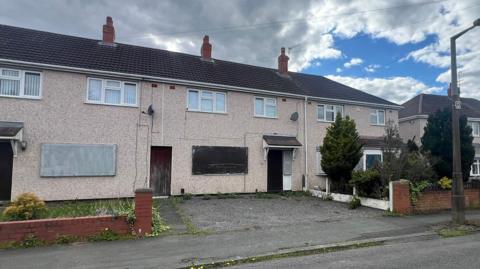 A row of three boarded up houses prefab houses on Gough Avenue in Wolverhampton