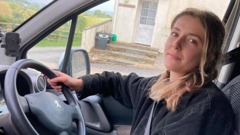 Ellie Rylands sitting behind the wheel of her car