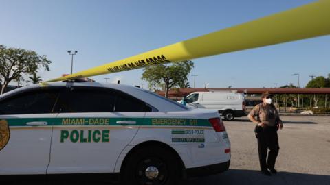 Officers examine the scene of a shooting outside a banquet hall in Hialeah, Florida