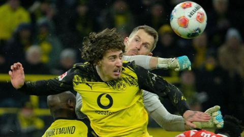Mainz' German goalkeeper #33 Daniel Batz punches the ball clear next to Dortmund's Portuguese forward #21 Fabio Silva during the German first division Bundesliga