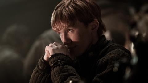 Tostig clasping his hands together and looking up