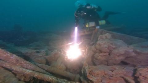 Diver looking at machinery on shipwreck