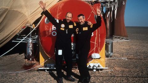 Bertrand Piccard and Brian Jones pictured by the balloon in the desert