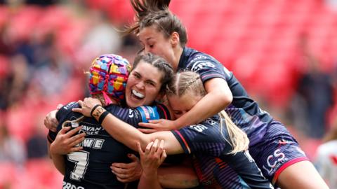 Wigan players celebrate Megan Williams' try