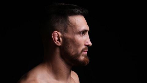 Side profile of Modestas Bukauskas after a fight against a black background