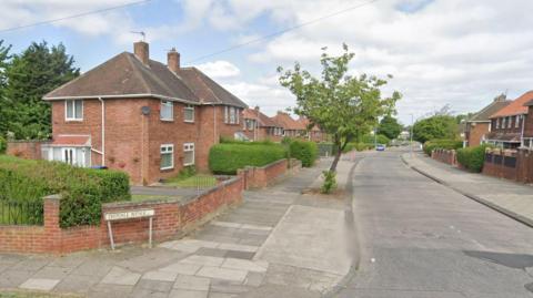 A view of Deepdale Avenue in Middlesbrough. Semi-detached houses line both sides of the street.