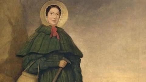 A painting of Anning wearing a bonnet and large green coat. She carries a walking stick and bag.