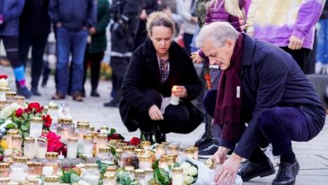 Prime Minister Jonas Gahr Stoere lays flowers during his visit to Kongsberg on Friday