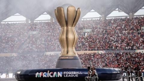 A giant inflatable replica of the African Football League trophy stands on the pitch during the tournament's opening ceremony inside a stadium