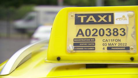 A taxi sign on top of a car