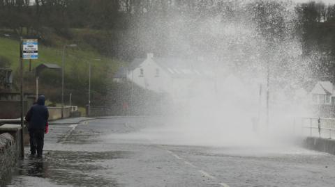 a person walking near stormy seas