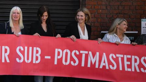 A group of sub-postmasters outside a court